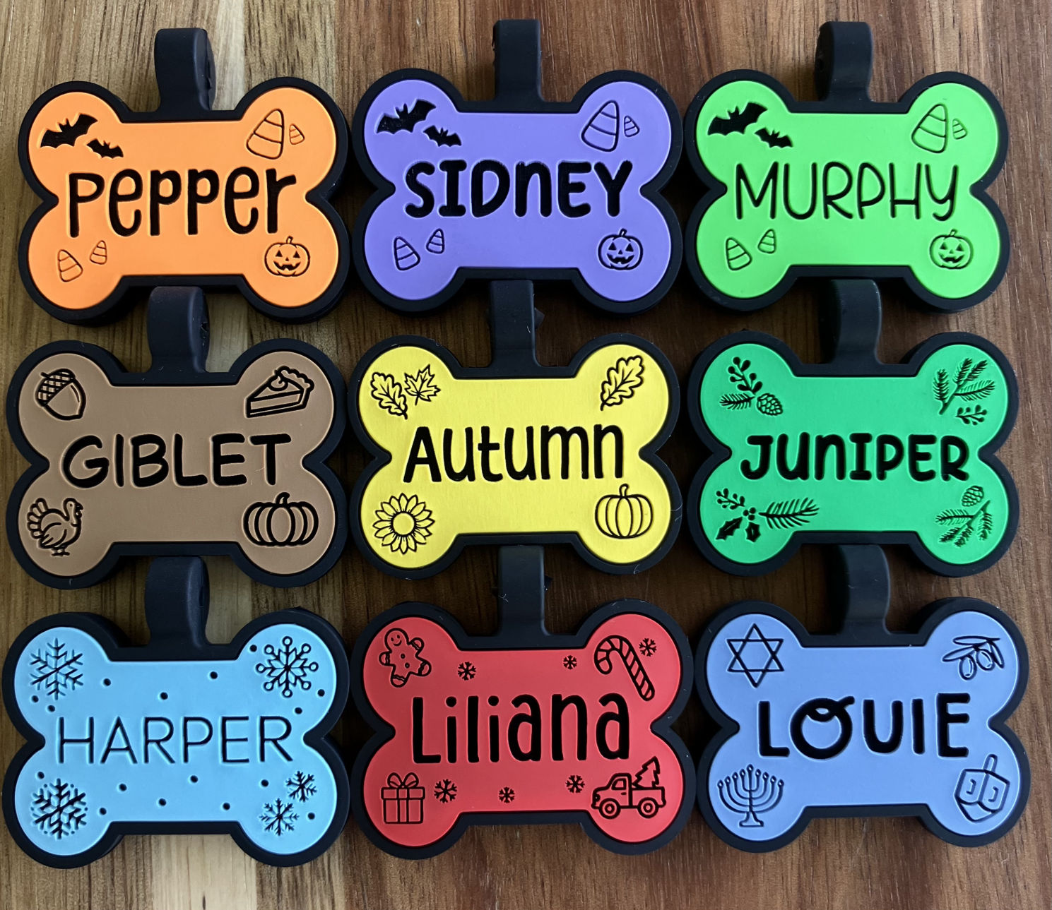 9 holiday themed silicone dog tags in different colors and shaped like bones